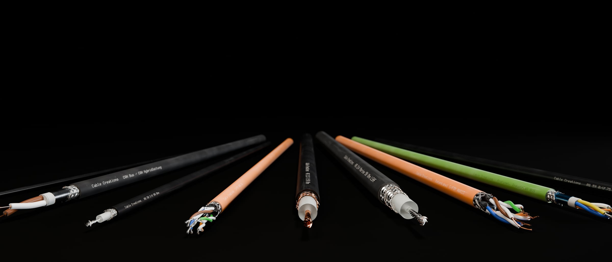 3D-Rendering: Ein Fächer von Kabeln im Breitformat – die neun Kabel der Bibliothek als Fächer, die Enden zur Kamera: RG 174, CAN-Bus, RG 58, S/FTP AWG 26, RG 213, RG 214 Marine, S/FTP AWG 23, Profinet und RG 59, im dunklen Studio, Aufdruck „Cable Creations“