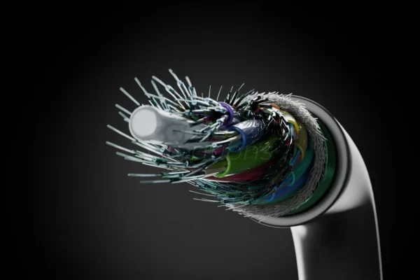 Toothbrush with colorful frayed bristles, close-up on dark background.